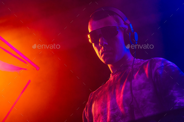Club DJ playing music at party wearing sunglasses - Stock Photo - Images