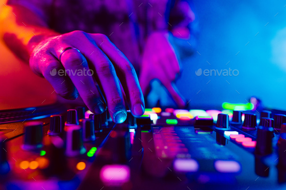 Close up of DJ hands on dj console mixer during concert in the club - Stock Photo - Images