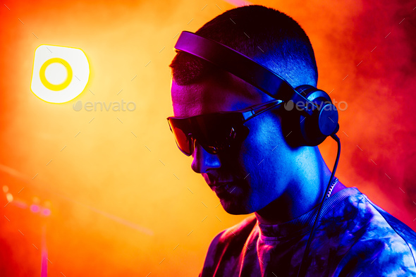 Club DJ playing music at party wearing sunglasses - Stock Photo - Images