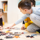 Children connecting jigsaw puzzle pieces in a kids room on floor at home.  - PhotoDune Item for Sale