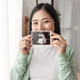 Asian pregnant smiling woman hand showing ultrasound scans at home. Pregnancy, maternity,  - PhotoDune Item for Sale