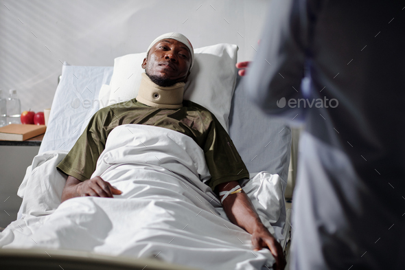 Soldier with injury lying on bed in hospital - Stock Photo - Images
