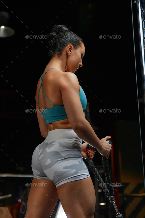 Fotografia do Stock: Muscular woman working out in gym doing exercise for  back. Strong fitness girl, muscles back