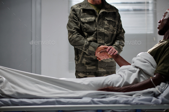 Soldier visiting his colleague in clinic - Stock Photo - Images