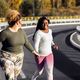 Two young plus size women jogging together on road. - PhotoDune Item for Sale