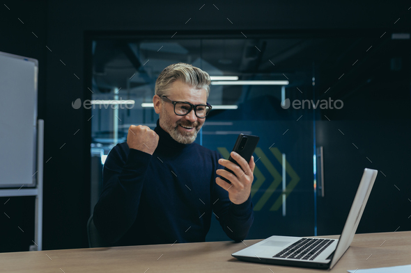 Businessman celebrating victory and success, mature gray haired man inside office got good news - Stock Photo - Images