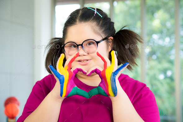 Autism disabled child kid complex genetic disorders down syndrome girl with colorful painted hands.