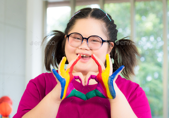Autism disabled child kid complex genetic disorders down syndrome girl with colorful painted hands.
