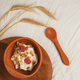 Modern brown silicone bowl of granola with yogurt, nuts and pair of ripe raspberries served on - PhotoDune Item for Sale