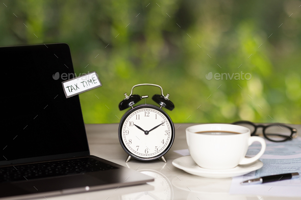 individual income tax return form for payment, alarm clock, coffee cup and laptop on working desk - Stock Photo - Images