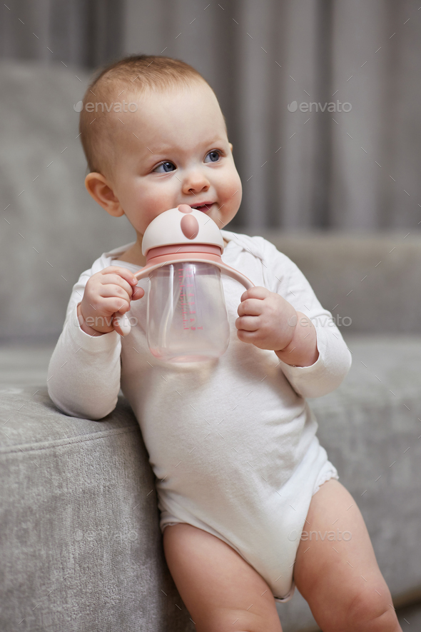 Toddler girl drinking water from the baby bottle Stock Photo