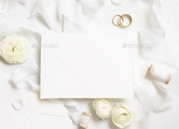 Blank card near cream roses, white silk ribbons and wedding rings top view, wedding mockup - Stock Photo - Images