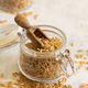 Glass jar of raw dry rye grain with a wooden spoon on white table close up - PhotoDune Item for Sale