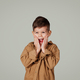 Cheerful shocked small european boy with open mouth holding hands to face - PhotoDune Item for Sale