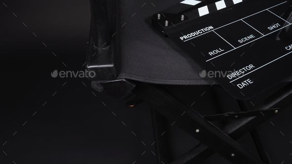 Clapperboard or clap board or movie slate with director chair on black background.