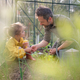 Father learning his little daughter to care about organic plants in eco greenhouse, sustainable - PhotoDune Item for Sale