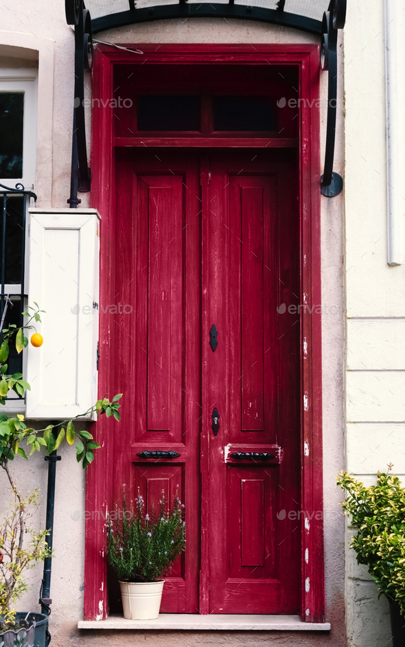 Entrance to the house with an old vintage wooden door in magenta color - Stock Photo - Images