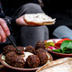 Close-up of women&#39;s hands holding bread and spreading hummus.  - PhotoDune Item for Sale