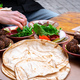 Close-up of female and male hands holding bread and spreading hummus.  - PhotoDune Item for Sale