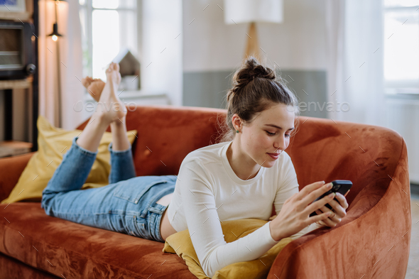 Young woman scrolling her smartphone in the apartment. - Stock Photo - Images