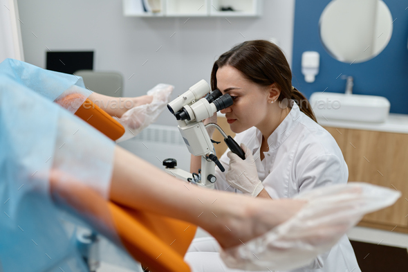 Gynecologist examining patient on chair with gynecological equipment ...