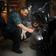 Mature man biker repairing motorcycle in garage at evening - PhotoDune Item for Sale