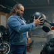 Side view shot on biker choosing new modern safety helmet in motorcycle shop - PhotoDune Item for Sale