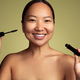 Smiling Asian woman with mascara in studio - PhotoDune Item for Sale