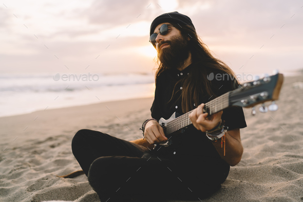 Amateur musician enjoying time for music meditation at seashore beach using Hawaiian ukulele,