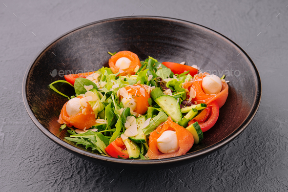 Salmon salad with mozzarella, tomato, cucumber on bowl