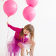 Funny kid girl celebrating birthday with balloons in room over white - PhotoDune Item for Sale