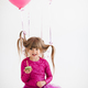 Funny kid girl celebrating birthday with balloons and cake in room over white - PhotoDune Item for Sale