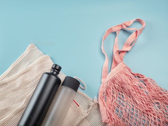 Cotton eco bags and water bottles on blue background. Zero waste concept - Stock Photo - Images