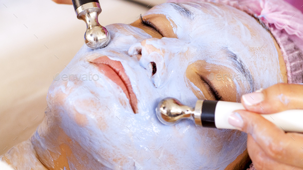 Woman in a spa salon on cosmetic procedures for facial care. Beautician makes medical procedures.  - Stock Photo - Images