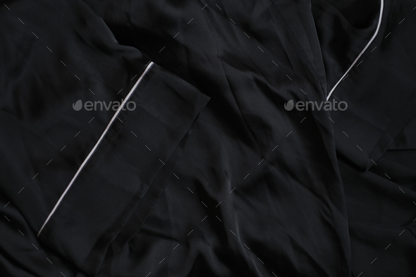 detail of a black wrinkled silk robe. fabric care, artificial textiles. dark background