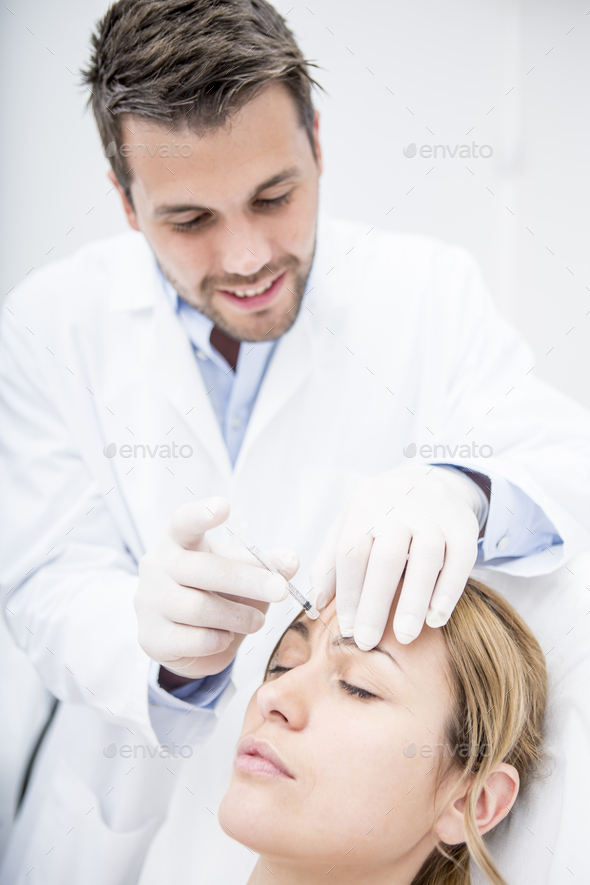 Aesthetic surgery, woman receiving injection into forehead