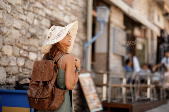 Happy woman walking through the town during her summer holiday. - Stock Photo - Images