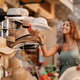Young happy woman choosing sun hat on street market. - PhotoDune Item for Sale
