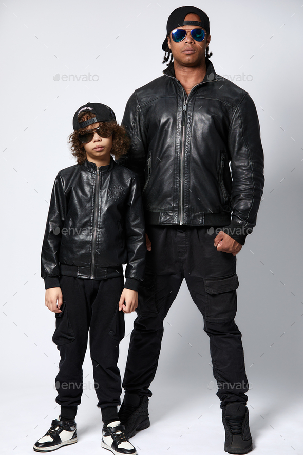 Handsome young Afro American father and his cute child are looking at