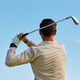 Back view of man swinging golf club against blue sky - PhotoDune Item for Sale