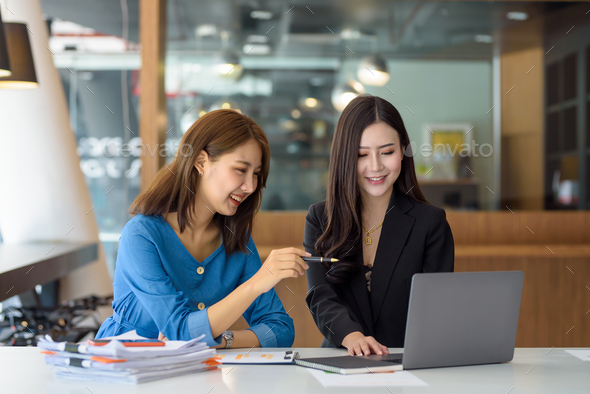 Two Young Asian Businesswomen Talk, Consult, Discuss Working With New ...