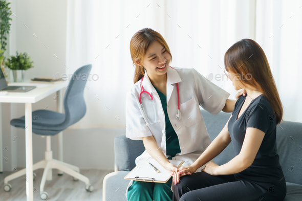 Asian female doctor asks about the patient's condition and makes recommendations about medications - Stock Photo - Images