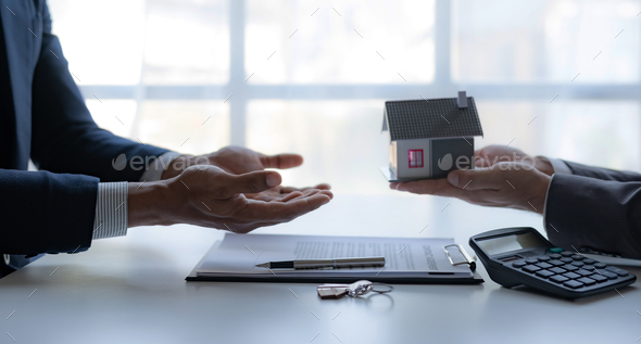 Real estate agent giving house key to the client after signing the real estate contract. - Stock Photo - Images