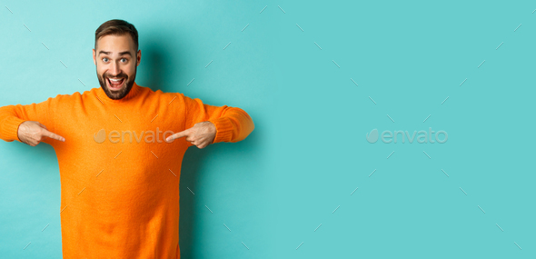 Happy man pointing at sweater, showing your logo banner on clothes ...