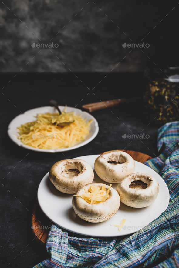 Stuffing mushrooms with grated cheese - Stock Photo - Images