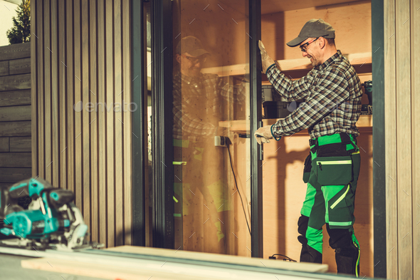 Contractor Installing Aluminium Frame Window Glass Doors Inside a Shed - Stock Photo - Images