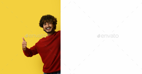 Happy indian man showing thumb up, posing by empty placard - Stock Photo - Images