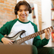 Korean Boy Playing Electric Guitar Near Laptop Sitting At Home - PhotoDune Item for Sale