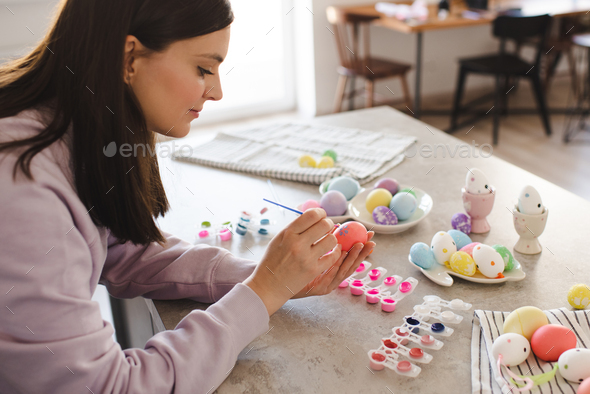 Woman making Easter decorations at home - Stock Photo - Images