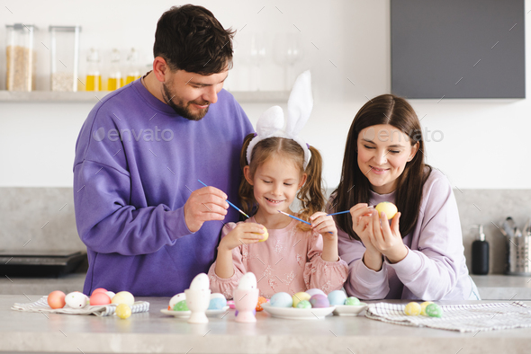 Happy family making Easter decorations together at home - Stock Photo - Images